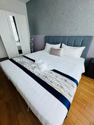 a large bed with white sheets and a blue headboard at Vortex Suites klcc by Rit in Kuala Lumpur