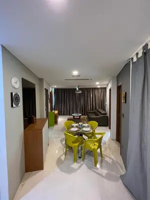 a living room with a table and yellow chairs at Vortex Suites klcc by Rit in Kuala Lumpur
