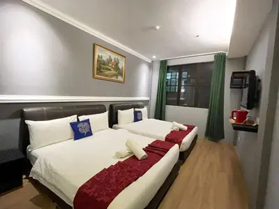 a bedroom with two beds and a window at Rae Hotel Bukit Bintang in Kuala Lumpur