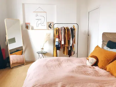 a bedroom with a bed and a rack of clothes at Arte City View by Sweethost in Kuala Lumpur
