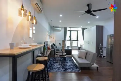 a kitchen and living room with a bar and chairs at Lily and Loft - Queensville @ Kuala Lumpur - Netflix in Kuala Lumpur