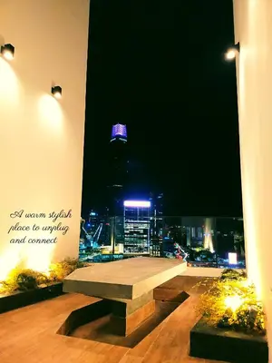 a bench in a room with a view of a city at Modern Suites 3Beds at Continew, TRX KLCC view, Next to IKEA in Kuala Lumpur