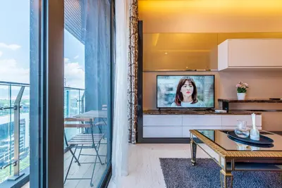 a living room with a tv and a table at Dorsett Residence Kuala Lumpur 15 in Kuala Lumpur
