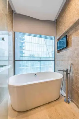a large bath tub in a bathroom with a window at Dorsett Residence Kuala Lumpur 15 in Kuala Lumpur