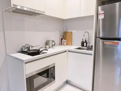 a white kitchen with a sink and a refrigerator at TRX Garden View TriBeCa 3min walk2 Pavillion 2bedroom in Kuala Lumpur