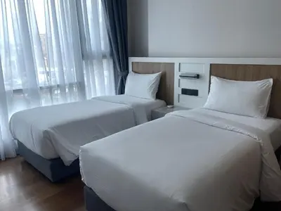two beds in a hotel room with windows at Opus Residences Warisan Merdeka by C&C Fortune in Kuala Lumpur