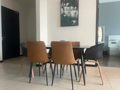 a dining room table with four chairs and a painting at Opus Residences Warisan Merdeka by C&C Fortune in Kuala Lumpur