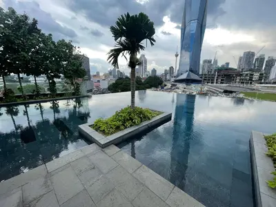 a pool with a palm tree in the middle of a city at Opus Residences Warisan Merdeka by C&C Fortune in Kuala Lumpur
