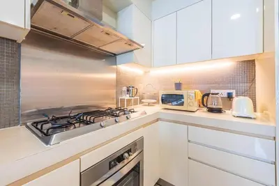 a kitchen with white cabinets and a stove top oven at 2min walk to Lot 10, 5 min to Pavillion 2BR 8-2 WIFI 100mbps in Kuala Lumpur