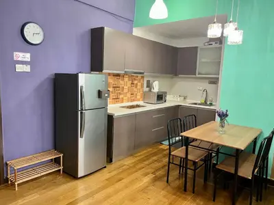 a kitchen with a refrigerator and a table with chairs at Luxury Regalia suites by adnan in Kuala Lumpur