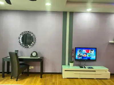 a room with a desk and a tv on a wall at Luxury Regalia suites by adnan in Kuala Lumpur