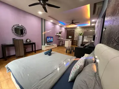 a bedroom with a large bed and a living room at Luxury Regalia suites by adnan in Kuala Lumpur