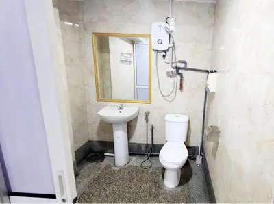 a bathroom with a sink and a toilet and a mirror at Holiday Hostel KLCC in Kuala Lumpur