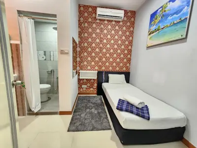 a small bedroom with a bed and a bathroom at Holiday Hostel KLCC in Kuala Lumpur