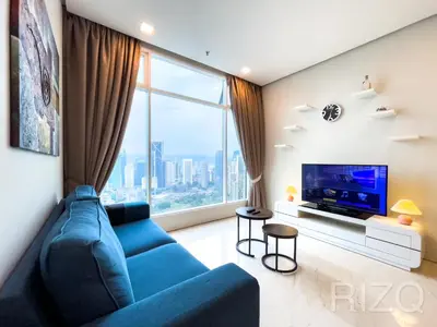 a living room with a blue couch and a large window at SOHO SUITES KLCC by Wonder Home in Kuala Lumpur
