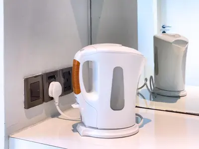 a white mixer on a counter next to a phone at SOHO SUITES KLCC by Wonder Home in Kuala Lumpur