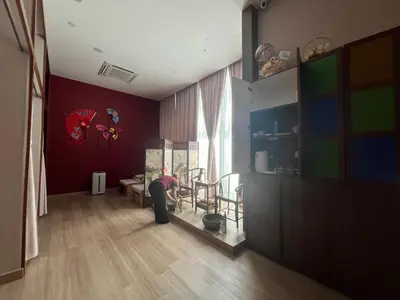 a woman bending over in a living room with a tv at Star Suite 5min Walk to KLCC Netflix in Kuala Lumpur