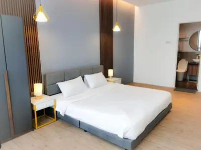 a bedroom with a large white bed with two lamps at The Parkville - Bangsar Trade Centre in Kuala Lumpur