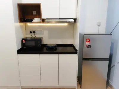 a small kitchen with a microwave and a refrigerator at The Parkville - Bangsar Trade Centre in Kuala Lumpur