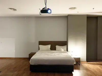 a bedroom with a large bed with white sheets at The Luxmi - Bangsar Trade Centre in Kuala Lumpur