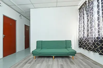 a green couch in a room with a wall at Hotel O Sri Rampai Metro Hostel in Kuala Lumpur