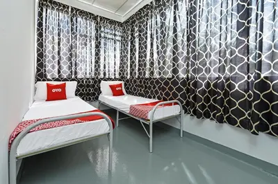 two beds in a room with black and white wallpaper at Hotel O Sri Rampai Metro Hostel in Kuala Lumpur