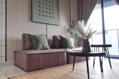 a living room with a brown couch and a table at Modern Designer Suite at Continew, TRX KLCC View, Next to IKEA in Kuala Lumpur