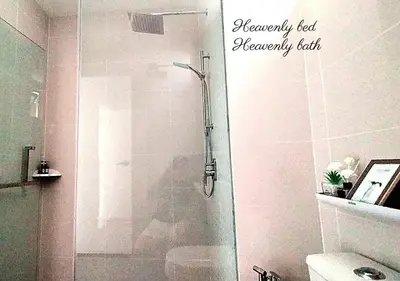 a shower with a glass door in a bathroom at Modern Designer Suite at Continew, TRX KLCC View, Next to IKEA in Kuala Lumpur