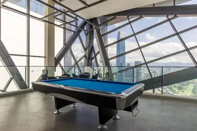 a pool table in a room with windows at Continew Residensi by Airhost in Kuala Lumpur
