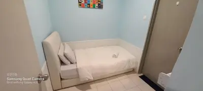 a small white bed in a small room at Taragon BBCC in Kuala Lumpur
