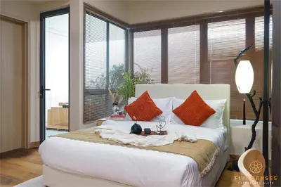 a bedroom with a large white bed with orange pillows at The Colony & The Luxe, Kuala Lumpur by Canopy Lives in Kuala Lumpur