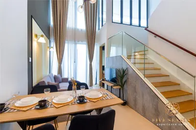 a dining room with a table and a staircase at The Colony & The Luxe, Kuala Lumpur by Canopy Lives in Kuala Lumpur