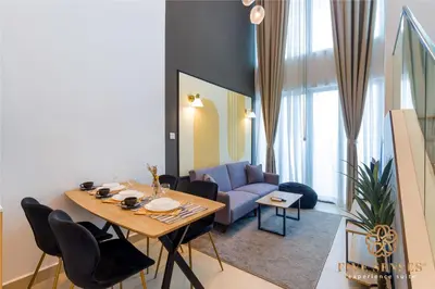 a living room with a table and a blue couch at The Colony & The Luxe, Kuala Lumpur by Canopy Lives in Kuala Lumpur