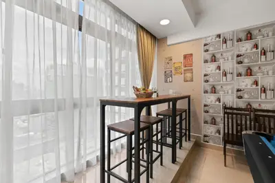 a dining room with a table and stools in front of a window at Fahenheit 88, Kuala Lumpur 17 in Kuala Lumpur
