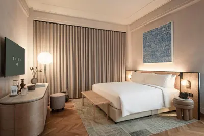 a bedroom with a large white bed and a desk at Else Kuala Lumpur, a member of Design Hotels in Kuala Lumpur