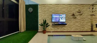 a room with a tv on a brick wall at Fahrenheit 88, Kuala Lumpur 11 in Kuala Lumpur