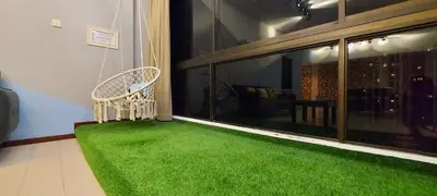 a room with a green rug and a chair on a balcony at Fahrenheit 88, Kuala Lumpur 11 in Kuala Lumpur