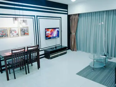 a living room with a dining table and a television at Mercu Summer Suites KLCC by Star Residence in Kuala Lumpur