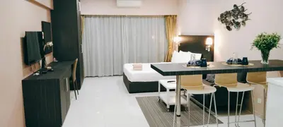 a hotel room with a bed and a table and chairs at Mercu Summer Suites KLCC by Star Residence in Kuala Lumpur