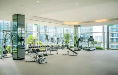 a gym with cardio equipment in a building with windows at 188 Suites KLCC by Signature Apartment in Kuala Lumpur