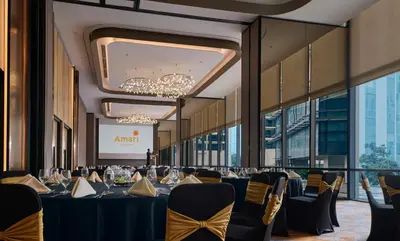 a banquet hall with tables and chairs and a screen at Amari Kuala Lumpur in Kuala Lumpur