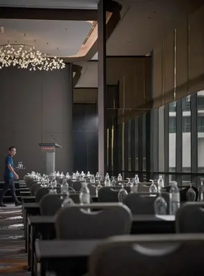 a row of chairs with a man walking in a room at Amari Kuala Lumpur in Kuala Lumpur