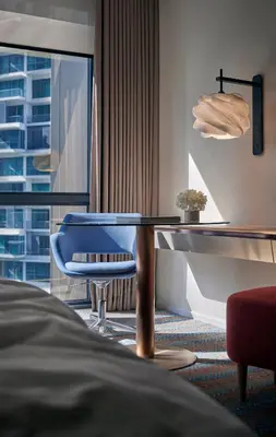 a hotel room with a table and a blue chair at Amari Kuala Lumpur in Kuala Lumpur