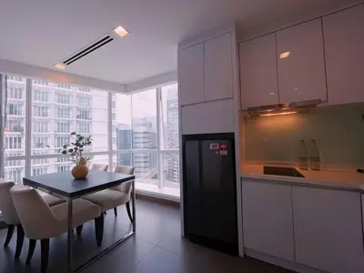 a kitchen with a black refrigerator and a table with chairs at 6PAX SUITES KL CITY Pavilion at Bukit Bintang NETFLIX & WIFI in Kuala Lumpur