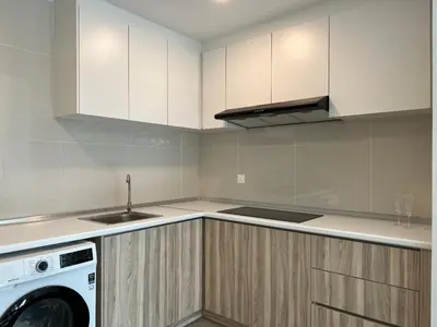 a kitchen with white cabinets and a washing machine at The Ooak Suites and Residence@ Kiara 163 in Kuala Lumpur