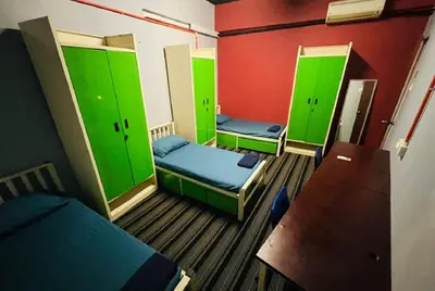 a room with three beds and green walls at RHV Bukit Bintang , Kuala Lumpur in Kuala Lumpur