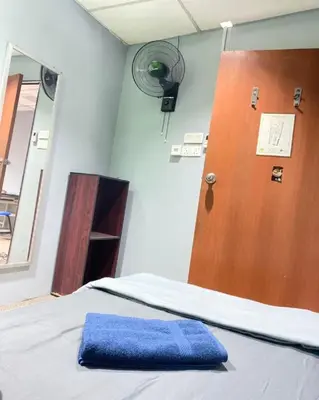 a bed with a blue pillow next to a door at RHV Bukit Bintang , Kuala Lumpur in Kuala Lumpur