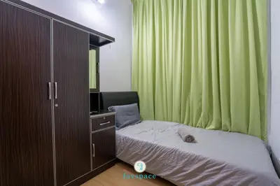 a bedroom with a bed and a cabinet with a mirror at Lovely 4-bedroom condo with pool for 6 pax - Cheras in Kuala Lumpur