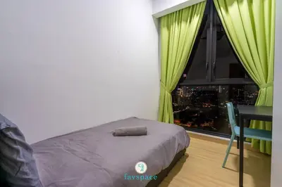 a bedroom with a bed and a table and a window at Lovely 4-bedroom condo with pool for 6 pax - Cheras in Kuala Lumpur
