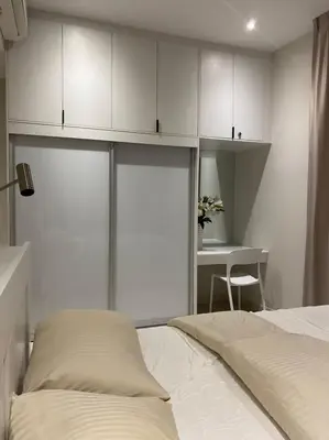 a bedroom with a bed and white cabinets and a table at Lovely Continew Residence 2 Bedrooms - KL in Kuala Lumpur